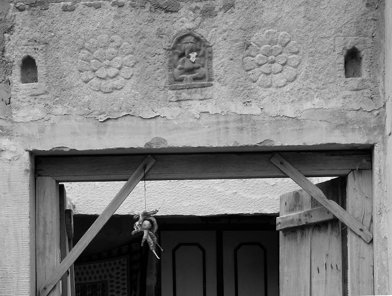 Chili peppers hang in a doorway under a Ganesha figurine in Jaisalmer Rajasthan