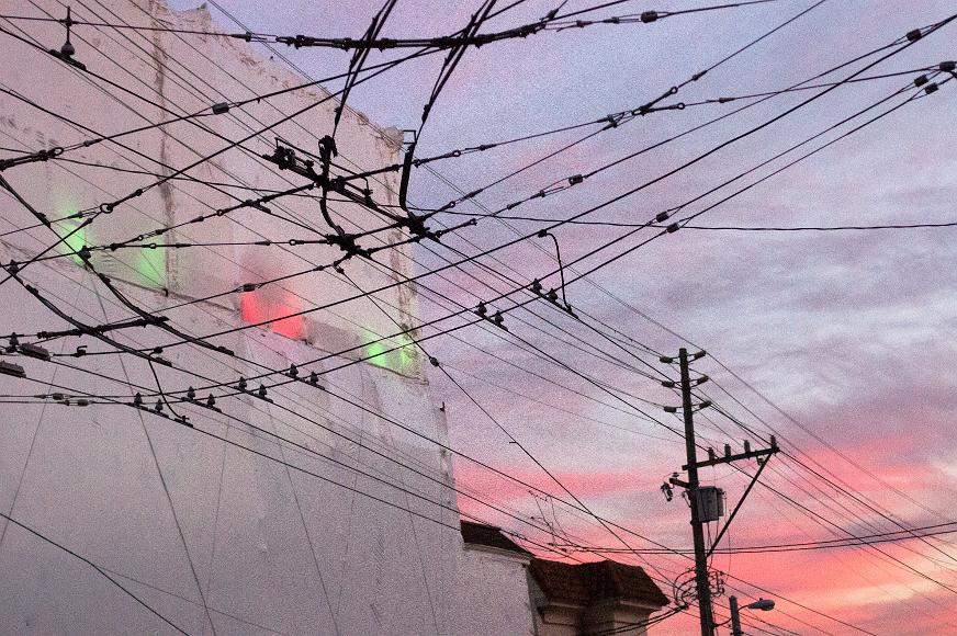 Christmas lights above the old Walgreens on Haight Shrink wrapped building underneath a sunset sky in the Lower Haight of San Francisco