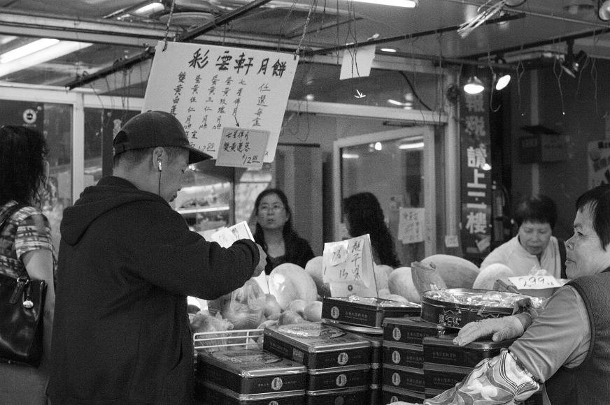 Shoppers in a Chinatown market Black and white image of Chinese shoppers shopping in a streetfront store with signs completely in Chinese