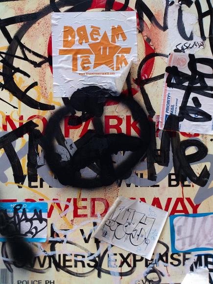 Graffiti on a no parking sign Graffiti and stickers in all colors but mostly black and red cover a sign in San Francisco California