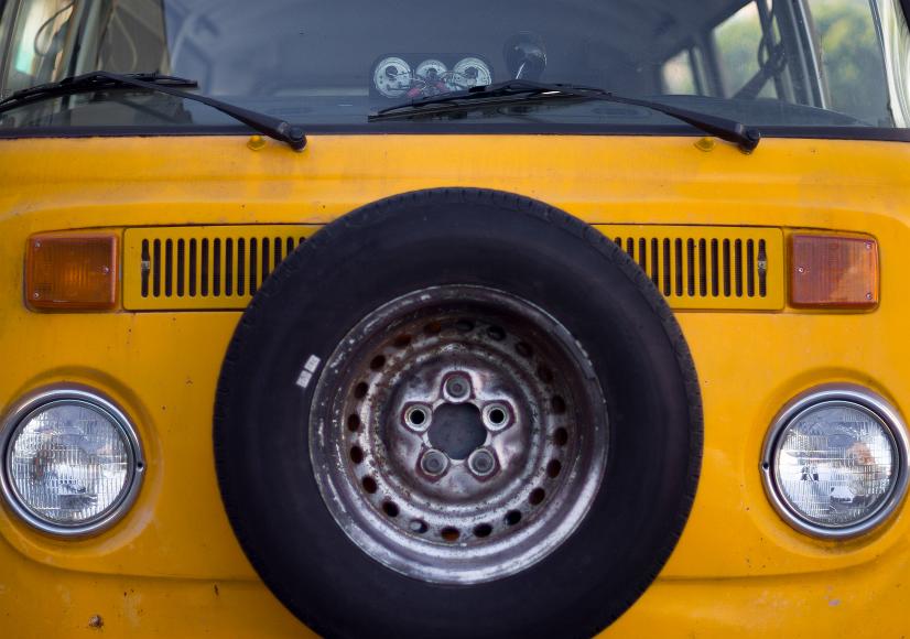 VW Bus Yellow VW Bus with rusted spare tire in front
