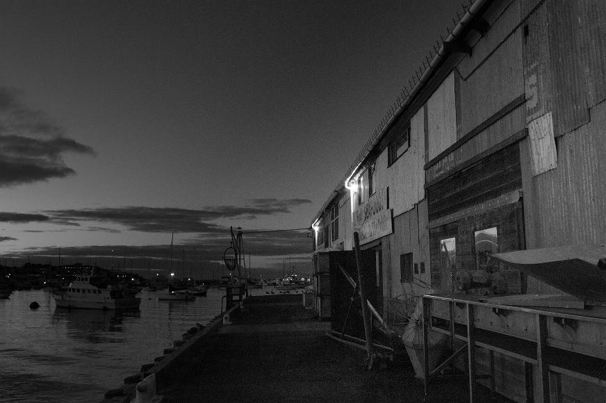 Monterrey Pier at night Seafood sotres on the pier and docked boats as seen from the pier at night