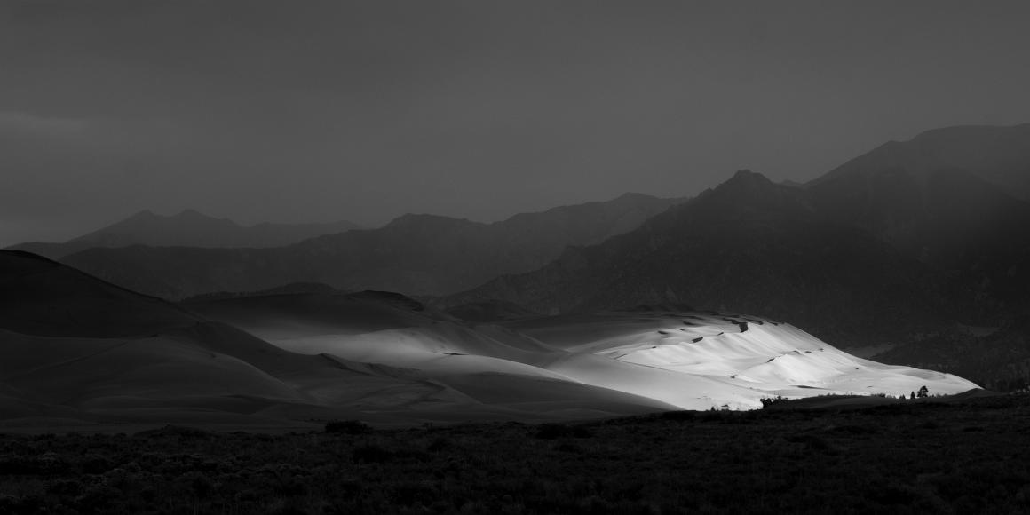 Storm and sand dunes sunbeams near my land Black and white image of sun dappled sand dunes at Great Sand Dunes National Monument against the Sangre de Christo Mountains in southern Colorado in the San...