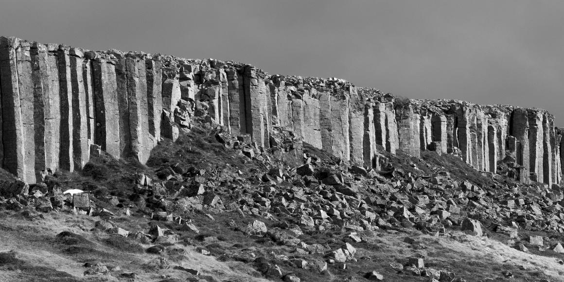 Gerðuberg Columnar Basalt Even hexagonal columns of volcanic stone form a cliff with crumbled blocks of basalt below
