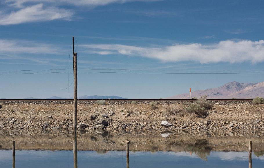 Nevada train tracks and reflecting pools Water reflecting power lines mountains railroad tracks and light clouds