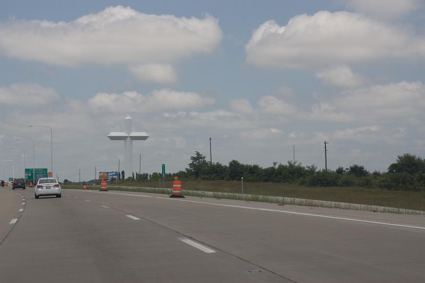 Big Cross A large white metal cross looms over a highway with construction signs at milepost 158 in Kansas