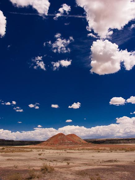 Deep blue sky fluffy clouds and painted hills in the Bisti Badlands of New Mexico