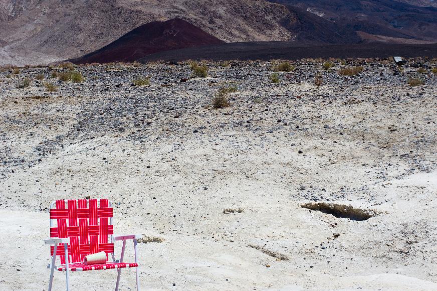 Lawn chairs Pink lawn chair on a baked moonscape in front of mountains in Death Valley National Park, California with A set of seats from a minvan or SUV in the far...