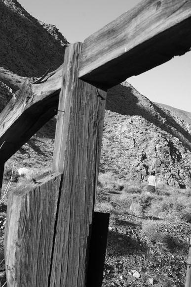 Wooden ruins and girl Sherene in front of old mining ruins, mineshafts, and a rocky valley
