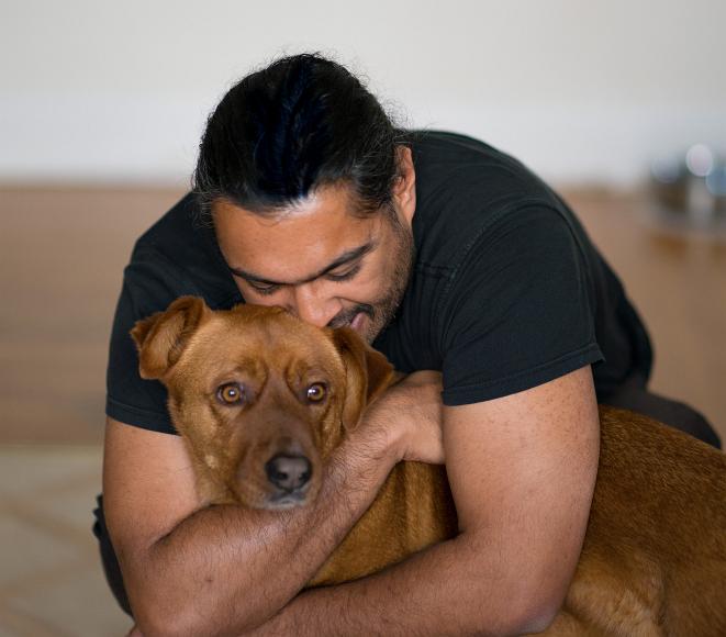 Rana hugs Cayenne A man hugs a brown dog