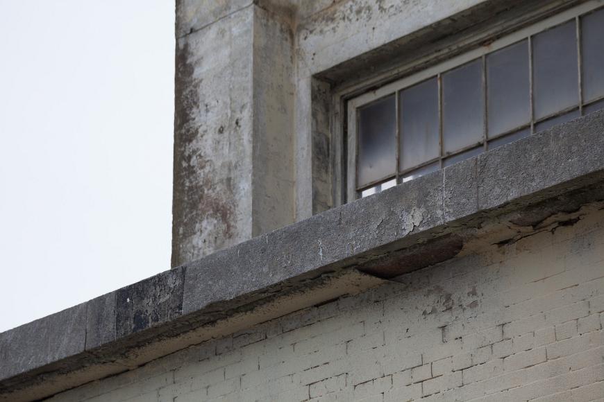 Alcatraz detail #1 The roof and a window on an old brick and concrete window on an overcast day