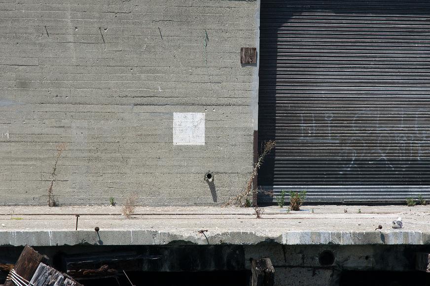 San Francisco Pier Detail #11 pier with concrete wall and corrugated metal door with crumbling dock below